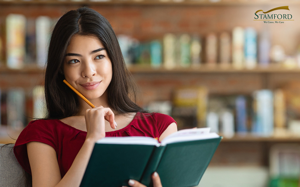 Image of a woman holding a pencil and a notebook and planning something