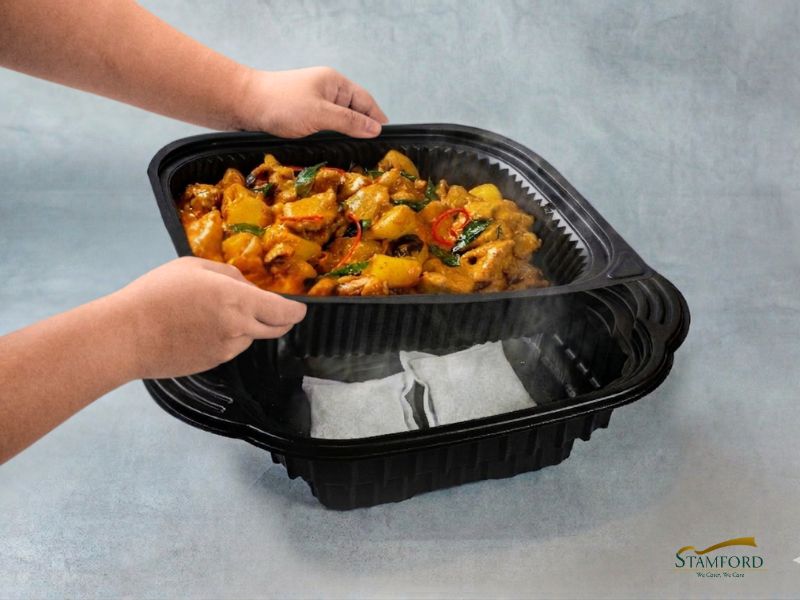 Step 2: Placing the second layer containing food into the deeper base tray